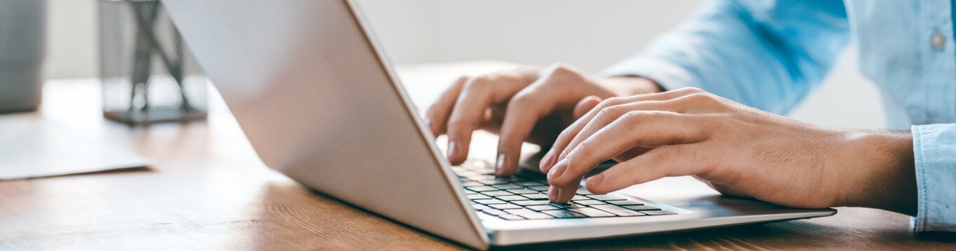 Persoon die op een laptop aan het typen is.