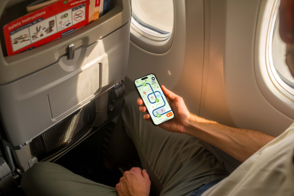 Online leren overal Man is online auto theorie aan het oefenen in het vliegtuig.