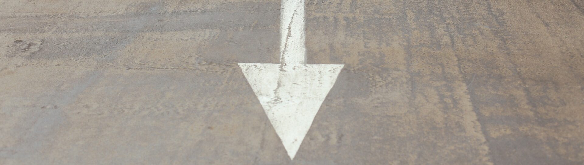 Een vloer met een witte pijl die naar beneden wijst.