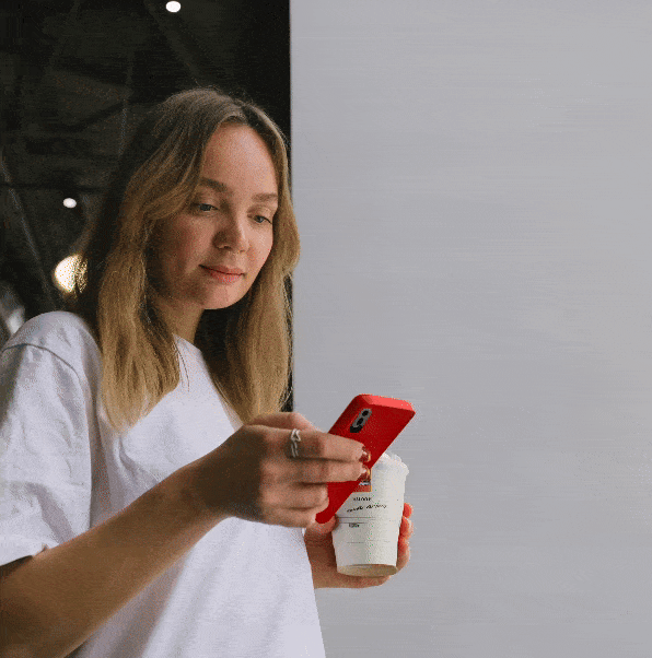 Een vrouw die een examenvraag in de online auto theorie app van Theorie Snel Halen beantwoord met een kopje koffie in haar hand.